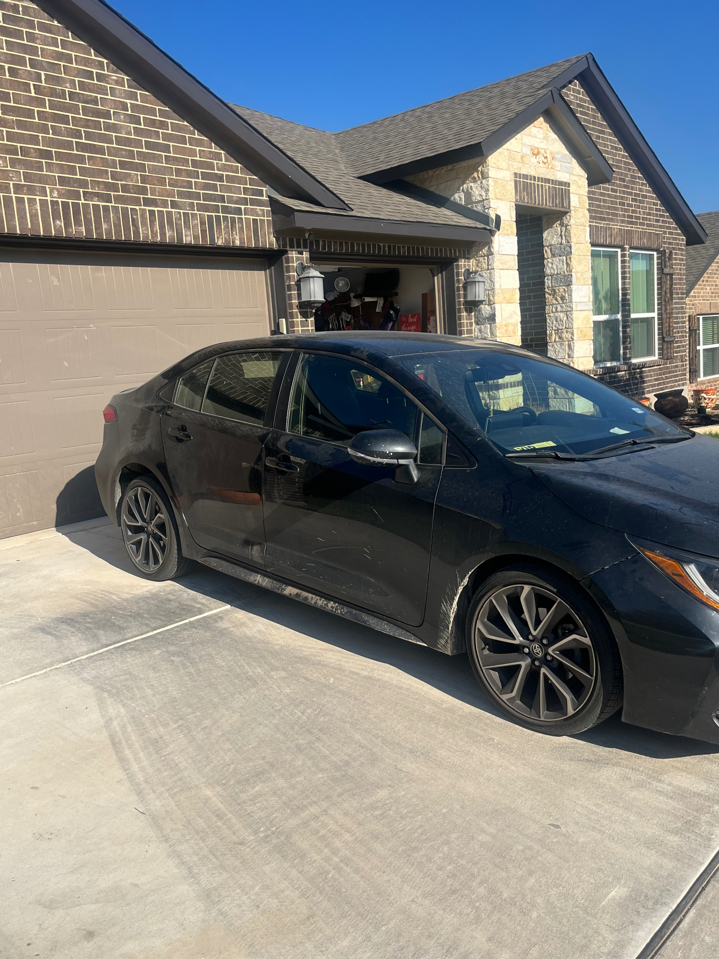 Black Toyota Corolla covered in dust and water spots before detailing