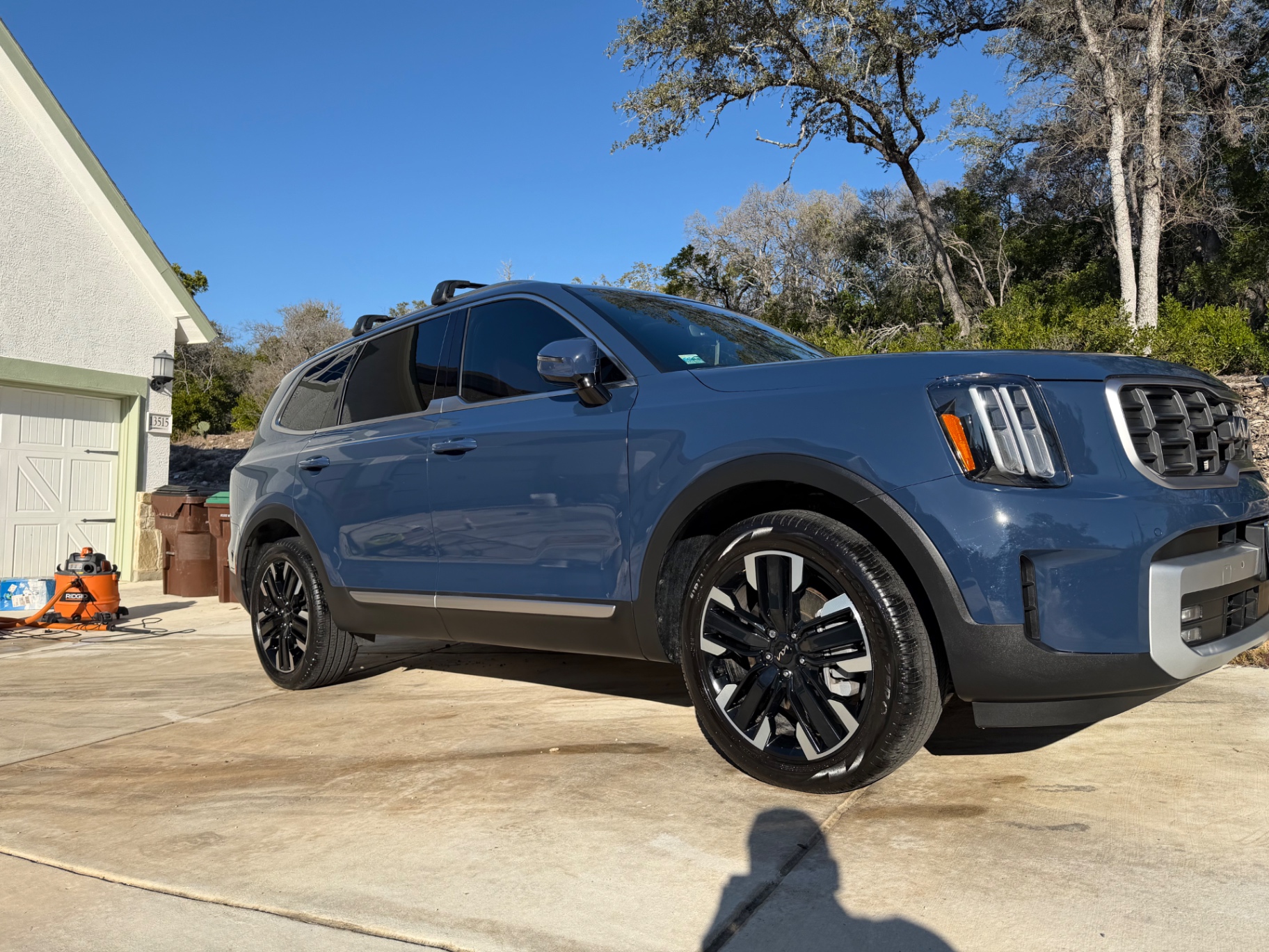 Blue Kia Telluride with a fresh gloss finish in a driveway